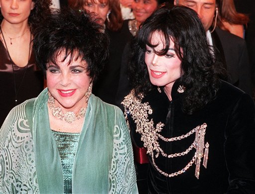 FILE - In this Feb. 16, 1998 file photo, actress Elizabeth Taylor arrives with pop singer Michael Jackson at the Pantages Theater in the Hollywood area of Los Angeles for a birthday celebration for Taylor. (AP Photo/Chris Pizzello, file)