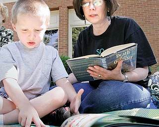 Carol Genova and her grandson Colin Genova, 5, of Niles, participate in a read-in at the main library in Warren Monday to bring attention to proposed library funding cuts.