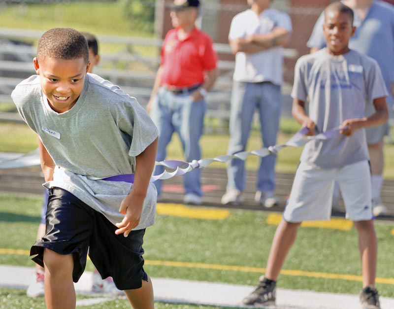 Jared Perdue, 9, of Youngstown and Aaron Woodberry, 11, of Youngstown participate in an exercise to test their agility during Cardinal Mooney Camp of Champions at the football field, Monday June 29, 2009.