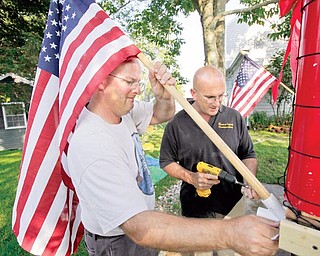 Kris Larson, left, and Peter Lopes attach an American flag to a soccer-themed Independence Day parade float in Bristol, R.I., Monday, June 30, 2009. Bristol residents have marked July 4th every year since 1785, allowing the town to lay claim to the nation's oldest Independence Day celebration.