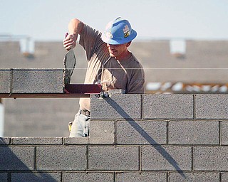 John Schreiber of Lencyk Masonry puts a brick and mortar in place at the South Range Schools facility being built on Route 46.