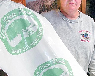 Billdunlap, an employee of Beaver Creek tate Park displays trashbags provided to park visitors. The park is in hte 2nd year of a carry out your trash program. wd lewis