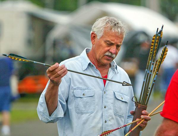 Tom Nega of Apollo, Pa. looks over an archery arrow at Dave and Ed's Swap Meet Friday at the Canfield Fairgrounds. Nega is an avid bow hunter and likes the antique arrows.