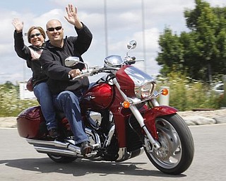 Todd and Mary Chuey of Hubbard wave to their friend as they start off their ride to raise money for several local charities, based at Harley Davidson Biketown in Austintown, Sunday
July 19 2009
Lisa-Ann Ishihara