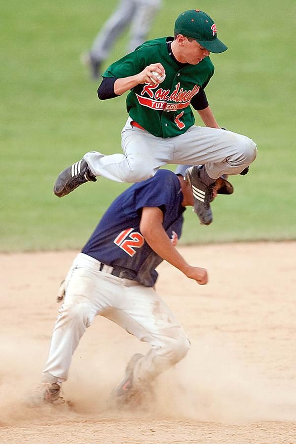 Rondinelli Tuxedo's Phil Lipari jumps over Ohio Hurricane's Joe Chiaroppa after outing him at second base during the fourth inning at Cene Field on Monday evening. 
