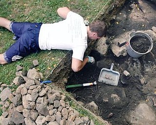 DIGGING DEEP: Joe Paloski, a graduate student at Youngstown State University, digs in a pit outside on the site of the former jail outside the old courthouse on Court Street in Canfield. The purpose of the dig was to explore the area’s history.