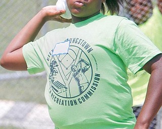 Natezia Figueroa, 10, of Youngstown, throws a shotput softball at the annual track and field day at Cardinal Mooney High School. The field day Friday for children in the summer day-camp program featured several events. 