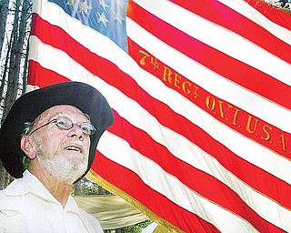 FLAGS OF OUR FATHERS: Jack Schinness, 73, of Chardon, stands in front of a Union flag embroidered with the text of the 7th Regiment of the Ohio Volunteer Infantry. Schinness is one of more than 200 volunteers who will perform in a Civil War re-enactment at Beaver Creek State Park in Columbiana County this weekend.