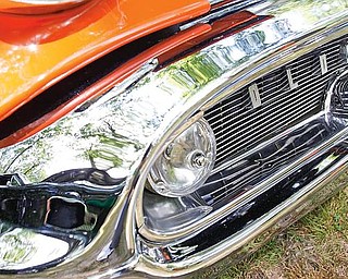 A black Chevy Chevelle is reflected in a 1957 orange Oldsmobile 88 during the 15th annual Thunder in the Park presented by the McDonald Fraternal Order of Police, at Woodland Park in McDonald, Sunday July 26, 2009.