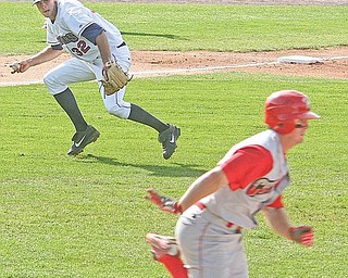 Pitcher Kyle Smith (32) of the Scrappers keeps his eye on the base runner as he tries to field a bunt attempt Sunday afternoon.