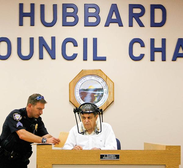 Hubbard Mayor Arthur U. Magee conducts mayor’s court Monday with assistance from Hubbard Police Sgt. David Oaks. The mayor is wearing a halo after breaking vertebrae in his neck. The mayor said he tried staying home but feels he’s better off doing something.