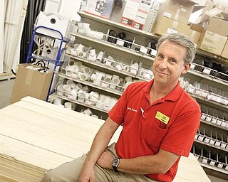BACK TO WORK: Dave Bishop of Boardman sits among the hardware supplies at Busy Beaver in Salem. After months of unemployment, Bishop has been working as the store’s assistant manager for about a month.