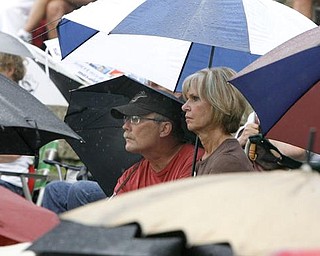 INTENTLY LISTENING - John VonMoos (37 years at Packard) ( warren) and Pat Stoner 35 -Niles - Years at Packard sit among a sea of umbrellas as they listen at the Retirees Unite, Packard hourly retirees group, is meeting to rally the troops against pension cuts- robertkyosay