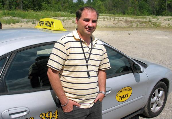 Robert Reizian, president of New Valley Taxi, stands by one of his cabs. Reizian says his employees are trained to avoid being robbed, but one employee failed to follow proper procedures when she was  robbed last weekend.