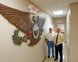 Joseph F. Gleydura, left, chairman of Hubbard Township trustees, and police Chief Todd D. Coonce stand next to a handcrafted wooden eagle featuring the township’s name along with the seal of Ohio. Made by Frederick Hanley, a trustee, the symbol dominates a wall in the newly renovated police department. The renovations updated the facility, built in 1978, and made it more efficient. 