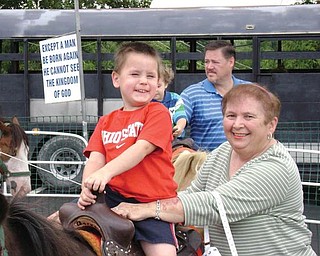Nicholas McGoogan of Poland enjoys a pony ride at Our Lady of Mount Carmel Festival in Youngstown. With him is his grandmother, Anita Regula of Campbell.