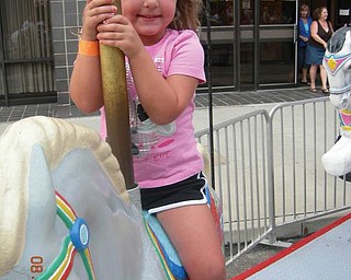 Samantha McKim of New Middletown couldn't resist the merry-go-round at the Greater Youngstown Italian Fest.