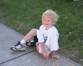 Ian Windsor, 3, is drawing a picture on the sidewalk at the Chalk it Up for Poland! chalk art contest (taken by Kayla Windsor).