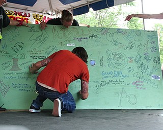 Dave Grohl signing the board at the David Grohl Alley dedication in Warren.