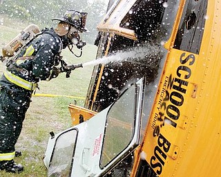 8.4.2009Firefighter/Medic, Chuck Wise, hoses down a school bus during an extraction exercise at the Liberty Fire Station along Logan Way on Tuesday afternoon.Geoffrey Hauschild