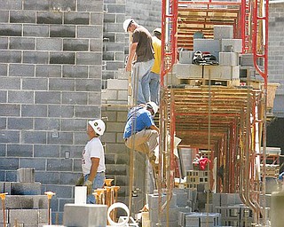 WALLS RISING: Workers from Lencik Masonry in Boardman lay cement block as the walls of the new Wilson Middle School in Youngstown begin to take shape.  The new school is being built on the same site as the former Wilson High School which was razed as part of a $190 million rebuilding program.