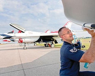 READY FOR SHOW: Staff Sgt. Chris McClure, number 4 assistant crew chief, wipes down an F-16 jet after the Air Force Thunderbirds arrived at the Vienna Air Base on Thursday in preparation for this weekend’s air show.  McClure is one of 130 people involved in the Thunderbirds show. He joined the Air Force eight years ago and has been with the Thunderbirds for the last three.