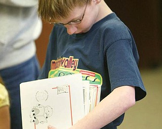 YOUNG PATRON: Nick Oblinsky, 9, of Girard does an inventory of the books he plans to check out at the Girard Free Library, 105. E. Prospect St. The library has trimmed staff, hours and programs because its funding from Libraries and Local Government Support Fund has been decreased from $1 million to $600,000 in the last eight years.  
