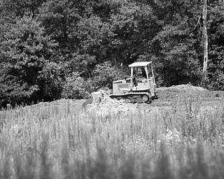 RESTORATION: A bulldozer moves dirt on the 48-acre site owned by the Mill Creek MetroParks system. The site, which used to be a sod farm, is being restored to its original wetland environment.