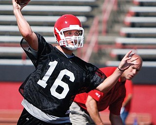CLEAN ATTACK: Youngstown State freshman Gannon Hulea (16) fires a pass downfield during practice on Thursday at Stambaugh Stadium. YSU linebackers coach Jerry Olsavsky looks on in the background.
