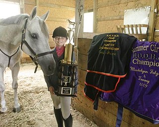 Madelynn Felgar with one of her trophys and horse blankets she won in 2009 with her horse - TOMMY - at their Beloit home - robertkyosay