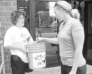 Special to The Vindicator
BENEFIT: Joey Ewing Wolanzyk, a teacher and volunteer at the Rich Center for Autism at Youngstown State University, gets a kick out of making a donation to the Give Autism the Boot fundraiser, which is the center’s major summer fundraiser. Accepting the contribution is Deb Maust, a parent volunteer.