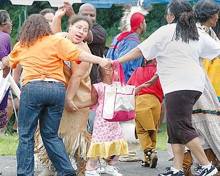 Dancers with the Red Hawk American Indian Cultural Society and people from the crowd at the Afrikan Cultural Weekend Fest dance to a native American song outside the Mill Creek Community Center Saturday, August 8th.