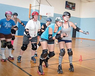 Mandy Tucker (second from right) squeezes past Natalie Clark (right), who tries to block her progress during a roller derby practice by the Little Steel Derby Girls at the Boys and Girls Club of Youngstown on Sunday evening.