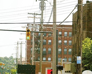 UGLY LINEUP: Youngstown State University wants Ohio Edison to remove these wooden utility poles from West Rayen Avenue and bury the wires where the university is building its $34.3 million business school, but the electric utility is balking at undertaking the task at the utility’s expense.