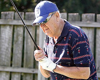 FORE-MAN: Joe Skebo, 78, of Youngstown, examines his club before teeing off. Skebo, who is visually impaired, plays with a group of golfers with similar ailments every week at the Par 3 Golf Course on McCollum Road.