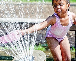 COOL TOUCH: Rihonne Johnson, 3, cools off in the fountain at Mill Creek Park. She was there with her mother, Ladawn Johnson, on Monday.