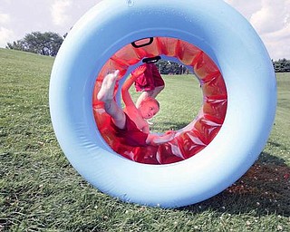 ON A ROLL: Isaiah Walter, 3, rolls down a hill in an inflatable tube at Mill Creek Park in Youngstown Monday. His father, Daniel Walter, of Youngstown, runs alongside the tube. With temperatures in the 90s Monday, Mill Creek Park seemed to be a popular place to beat the heat.