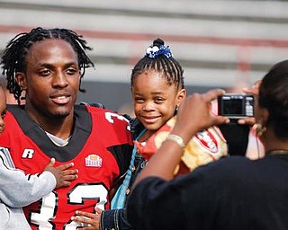 Lenny Wicks poses for his mom, Yvonne, holding his two children, 2-and-a-half old Lenny Jr. and 4-year-old Nevaeh at YSU's football photo day.
