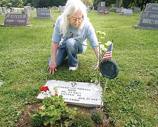 HERO'S STONE: Pattie Powell Scoville places flowers on the grave of her brother, Navy Corpsmen Richard Powell, who was killed in action in Vietnam. Powell is buried at Lake Park Cemetery on Midlothian Boulevard in Boardman.