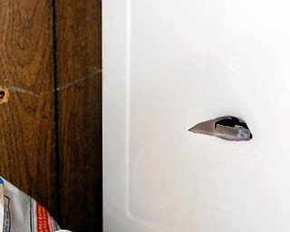 SMALL HOLE, BIG REMINDER: A hole in a dryer is a grim reminder of the violence that takes place outside the Francis Humphries East Side home and often spills over into the family home. Humphries says he is tired of the gunfire and noise around his home in the late-night hours.