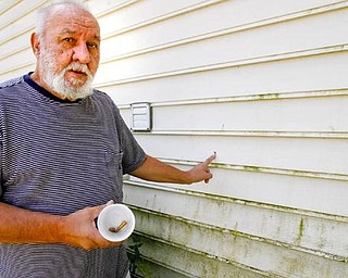 ONE FAMILY’S STRUGGLE: Francis Humphries, of Albert Street, holds a bullet and shell casing he collected on his property after his home was recently hit with gunfire. He can point to the multiple bullet holes in the siding of his house and has taken to recording late-night activity around his home.