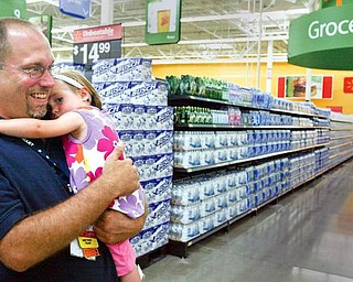 READY FOR SHOPPERS: Jason Steele of Austintown, a Wal-Mart associate who works in stock, hugs his 21-month-old daughter, NancyRose, as they walk through aisles of the new store that opens today. An open house took place Tuesday for business people, community leaders and family and friends of store employees. Steele was laid off from Delphi Packard Electric.