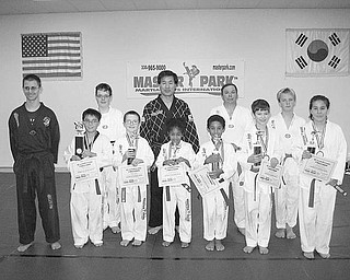 Special to The Vindicator
REGIONAL CHAMPS: Students of Master Park Martial Arts International display trophies they won by competing in various forms of marital arts at the regional U.S. Martial Arts Championship event. Pictured above after the competition are, from left,in front, Craig Mihalik, William Anderson, Wyatt Miller, Smeera Murad, Zeemeer Murad, Isaiah McInnis and Samantha Anderson; and, in back, Tommy Sodeman, Master Park, Dr. Richard Bacha and Richard Abel. Also winning trophies but not pictured with the champions are Evan Croutch, Jimmy Vaugh, Aaron Patton and Alan Petragel. Below, Evan Croutch demonstrates how he won the breaking competition with a flying jumping sidekick over obstacles.