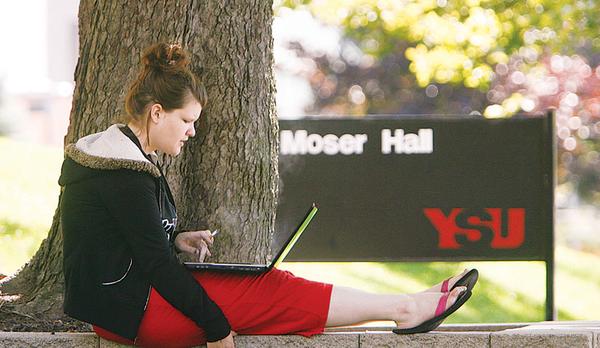 ENROLLMENT UP: Freshman Rachel Clifton of Hubbard, took a moment between classes to check her schedule as Youngstown State University. University officials said first-day enrollment Monday for the fall semester reached 14,425, the highest number in 16 years.