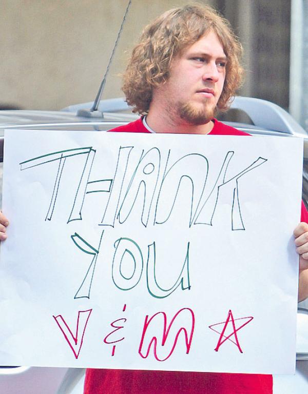 Tom Lordi holds a sign on Federal Street thanking V&M Star Steel.