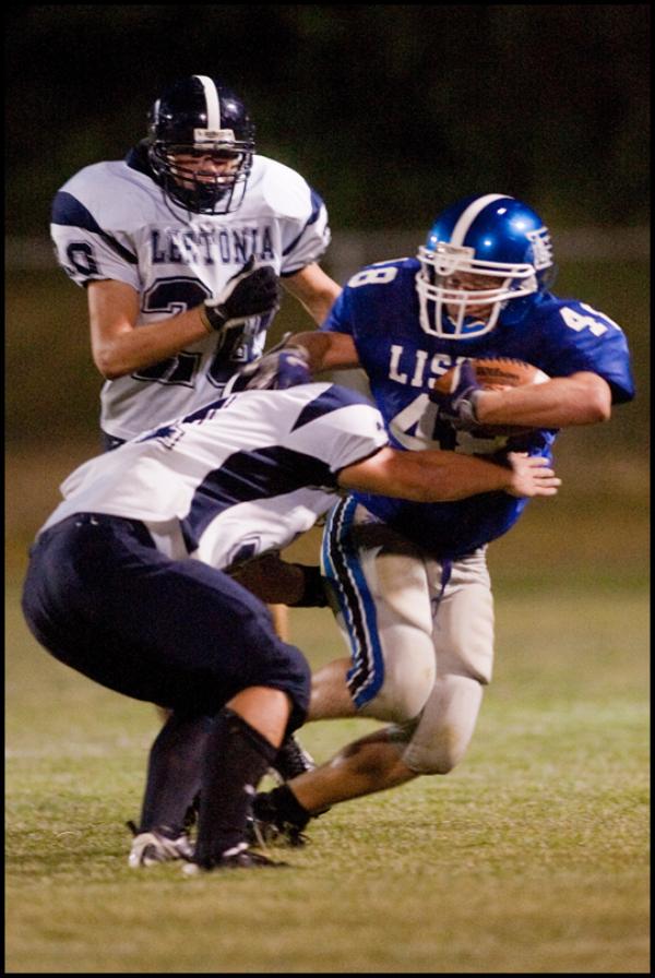 The Vindicator/Geoffrey Hauschild
Lisbon's Robert Wilcox drives down the field thwarting a tackle by Leetonia's Devan Miller in front of teamate Dalton Scutt during the second quarter at Lisbon. Leetonia went on to defeat Lisbon 41-7.
8.27.2009