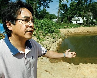 SHRIMPING: Ron Eiselstein of Youngstown gestures toward the pond on the city&#8217;s far East Side where he is growing Malaysian prawn, which are freshwater shrimp. In his hand he is holding a shell or skin the prawn leaves behind when it molts.
