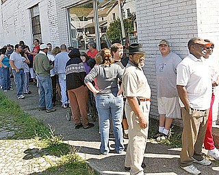 TILE ENTHUSIASTS: Dozens of people stand outside a vacant tile store on Mahoning Avenue. The old Wall Tile Co. hasn’t served customers in more than a year and the building’s landlord treated more than 100 people to the tile and supply contents of the building free of charge Wednesday.