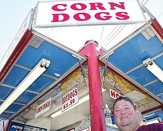 HOT DOG HEAVEN:  Leslie Hull, of Mount Gilead, stands in from of his concession at the Canfield Fair. Hull says despite a stagnant economy, many vendors have seen a steady stream of sales.