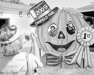 Inga Farragher of Boardman snaps a photo of her son Matt Farragher and Candace Rice. Matt and Candace are visiting from Texas. They were taking the photo near the pumpkin and squash exhibit at the Canfield fair Thursday. wdlewis